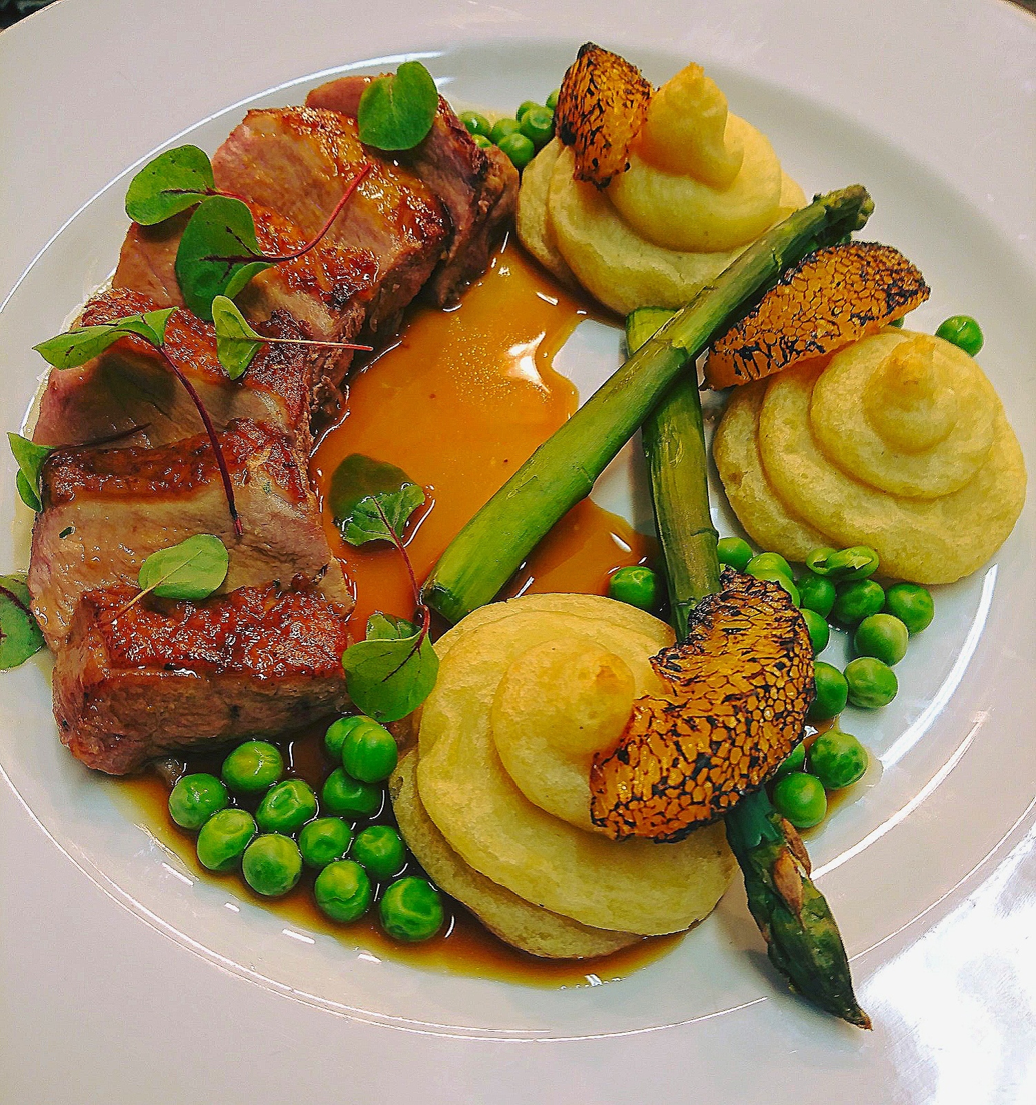 Pan seared duck-breast, duchess potatoes, asparagus, peas, burnt orange segments, finished with orange & thyme-jus