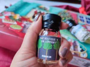 A hand holds a dram contained in the gin advent calendar
